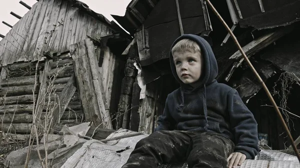 悲伤的无家可归的孤儿坐在废弃的建筑旁边 — 图库照片