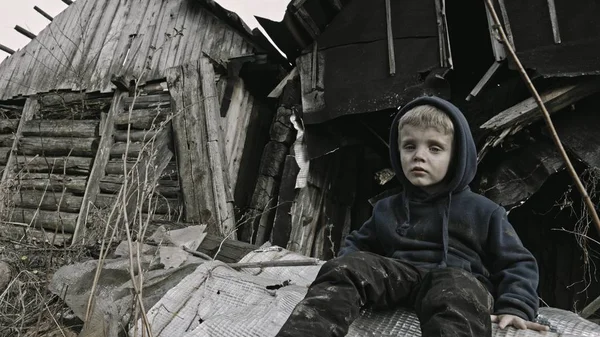 坐在废弃建筑旁的悲伤的小孤儿 — 图库照片