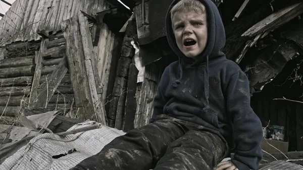 ちっちゃなホームレス孤児の横に泣いている放棄された建物 — ストック写真