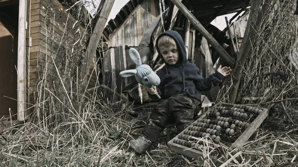 肮脏的孤儿男孩玩垃圾在废弃的村庄 — 图库照片