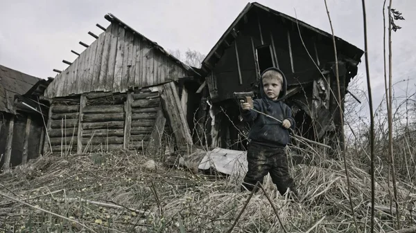 ホームレスの白人少年が放棄された村の銃で遊んで — ストック写真