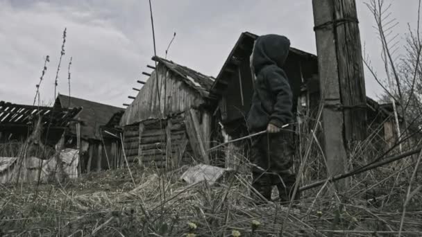 放棄された村の銃で遊んでホームレスの汚い少年 — ストック動画