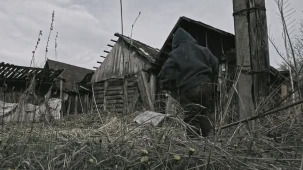 放棄された村の銃で遊んでホームレスの汚い少年 — ストック動画