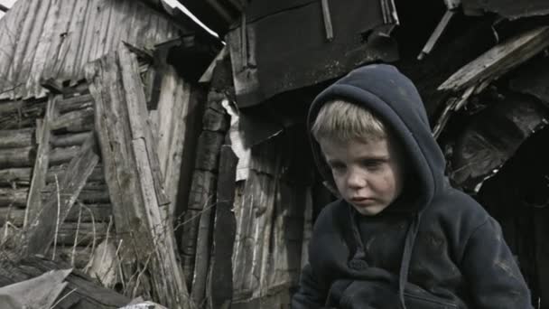 放棄された村に座っている悲しいホームレス少年 — ストック動画