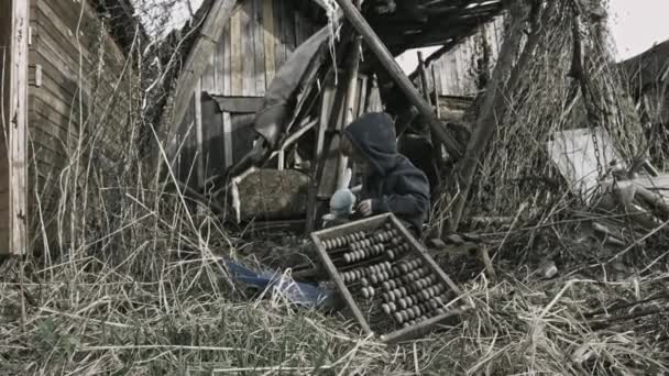 放棄された村のゴミで遊んでホームレスは孤児の少年 — ストック動画