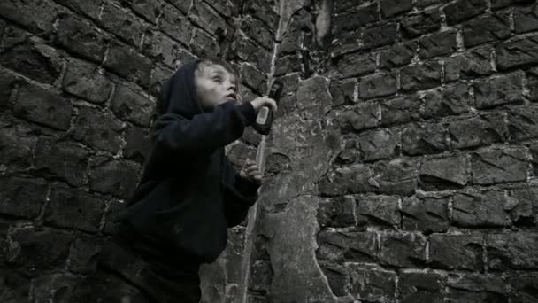 断念された建物に銃で遊んでホームレスの汚い少年 — ストック動画