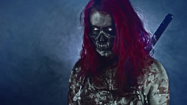 红发的女性僵尸杀手摆姿势与片假名对雾蒙蒙的蓝色背景与背光 — 图库视频影像
