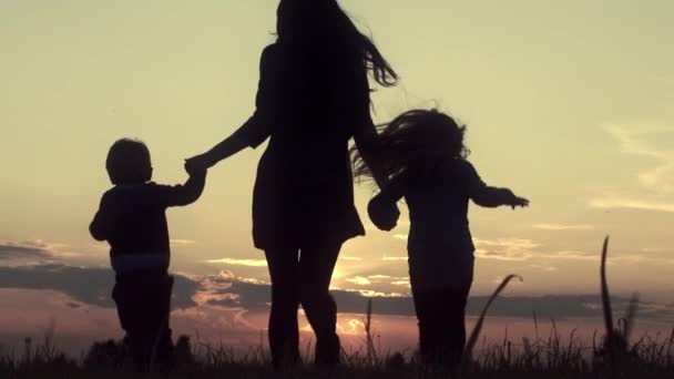 Νεαρή Μητέρα Παιδιά Τρέχουν Στο Πεδίο Στο Ηλιοβασίλεμα — Αρχείο Βίντεο