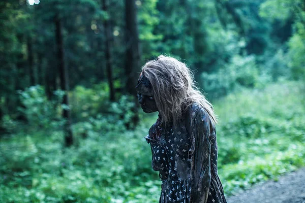 邪悪なゾンビ女性が林道でポーズの側面図 — ストック写真