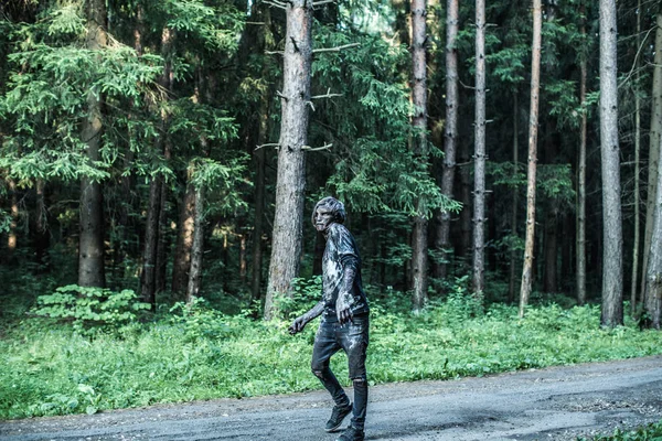 scary zombie man posing on forest path