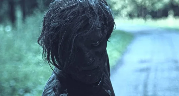 特写镜头肖像可怕的僵尸男子摆在森林路径 — 图库照片