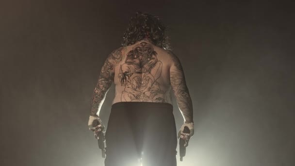纹身可怕的小丑摆姿势与枪对雾蒙蒙的背景 — 图库视频影像