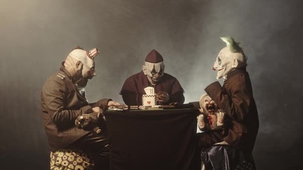 可怕的小丑坐在桌子上 在赌场玩扑克的钱 — 图库视频影像