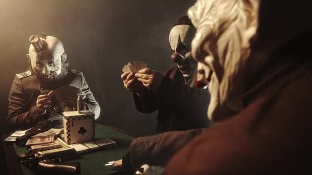 Τρομακτικό Κλόουν Κάθεται Στο Τραπέζι Και Παίζετε Πόκερ Για Χρήματα — Αρχείο Βίντεο