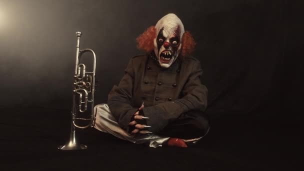 Scary Clown Sitting Trumpet Misty Background — Stock Video