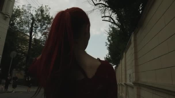 路上で赤い頭の女性吸血鬼の背面図 — ストック動画