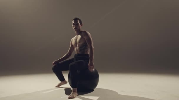 Jongeman Danser Maken Van Oefeningen Met Yoga Bal Studio — Stockvideo