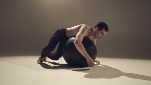 年轻男子舞蹈演员做运动与瑜伽球在演播室 — 图库视频影像