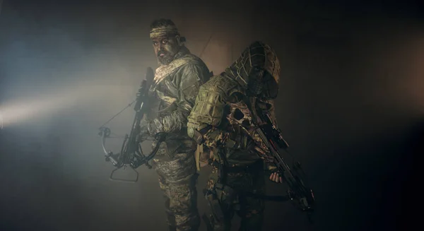 Två Manliga Jägare Kamouflage Med Armborst Poserar Mot Mörk Bakgrund — Stockfoto