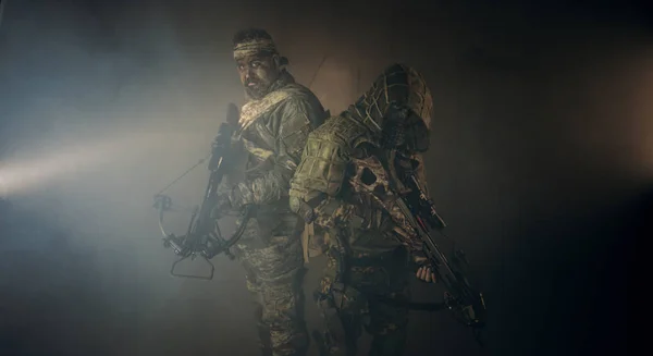 Två Manliga Jägare Kamouflage Med Armborst Poserar Mot Mörk Bakgrund — Stockfoto