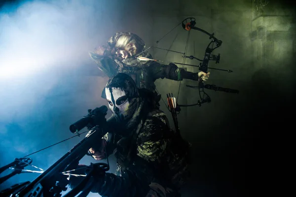 近代的な武器ポーズに対する男性と女性のハンター グレー背景 — ストック写真