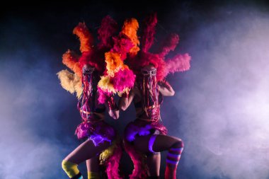 young can-can dancers with pom-poms posing together in carnival concept against misty background clipart