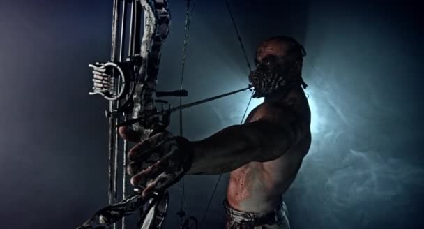 Muskulös Zombie Killer Med Moderna Båge Poserar Mot Mörk Bakgrund — Stockvideo