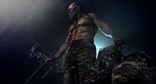 肌肉发达的僵尸杀手与现代弓和僵尸头摆姿势在黑暗的背景 — 图库视频影像