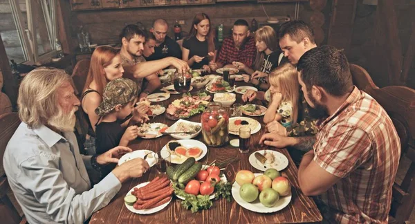 Przyjaciele Rodzina Siedzi Drewnianej Chaty Myśliwych Obiad Tabeli Pełnej Jedzenia — Zdjęcie stockowe