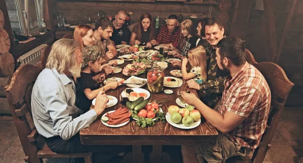 Przyjaciele Rodzina Siedzi Drewnianej Chaty Myśliwych Obiad Tabeli Pełnej Jedzenia — Zdjęcie stockowe