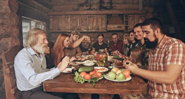 Друзья Семья Сидящие Хижине Охотников Деревом Обедающие Столом Полным Еды — стоковое фото
