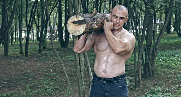 Muscoloso Uomo Caucasico Possesso Log Nella Foresta — Foto Stock