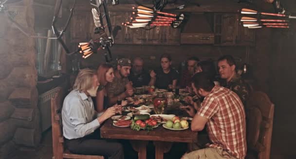 Gran Grupo Amigos Familiares Sentados Cabaña Los Cazadores Madera Cenando — Vídeo de stock