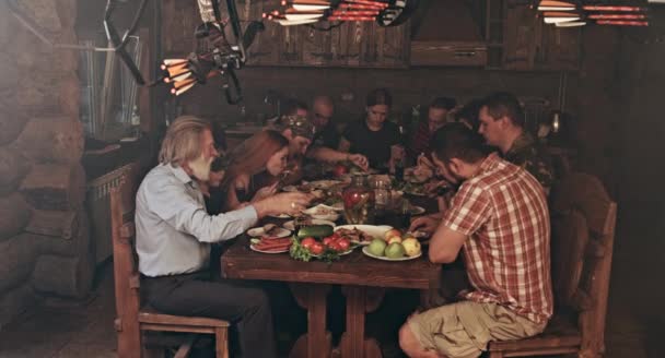 Large Group Friends Family Sitting Wooden Hunters Shack Having Dinner — Stock Video