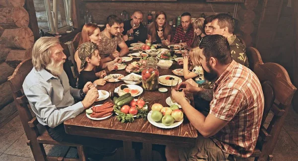 Friends Family Sitting Wooden Hunters Hut Having Dinner Table Full — Stock Photo, Image