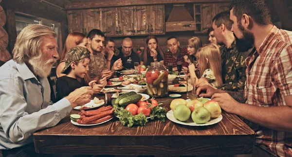 Duża Grupa Przyjaciół Rodziny Siedzi Drewnianych Myśliwych Shack Obiad Tabeli — Zdjęcie stockowe