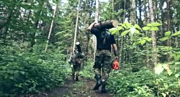 Two Men Carrying Logs Green Forest — Stock Video