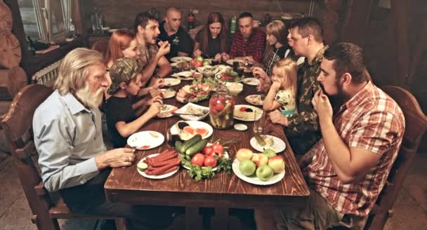 Gran Grupo Amigos Familiares Sentados Cabaña Los Cazadores Madera Cenando — Vídeo de stock