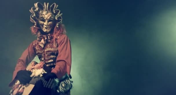 Homem Carnaval Traje Veneziano Máscara Tocando Guitarra Contra Fundo Enevoado — Vídeo de Stock