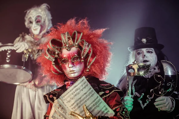 Gruselige Festmusiker Venezianischen Kostümen Posieren Vor Dunklem Hintergrund — Stockfoto