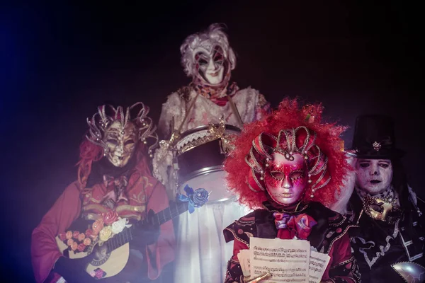 Gruselige Festmusiker Venezianischen Kostümen Posieren Vor Dunklem Hintergrund — Stockfoto