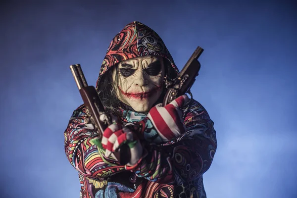 Läskig Clown Mannen Huven Poserar Med Kanoner Mot Dimmiga Bakgrund — Stockfoto