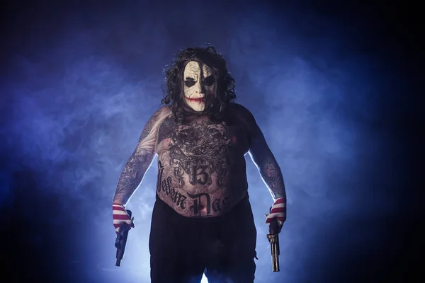 Tatuerade Scary Clown Poserar Med Kanoner Mot Dimmiga Bakgrund — Stockfoto