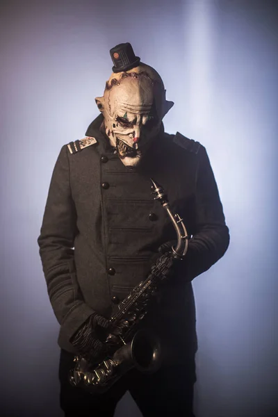Hrůzostrašný Klaun Pózuje Saxofon Proti Tmavým Pozadím — Stock fotografie