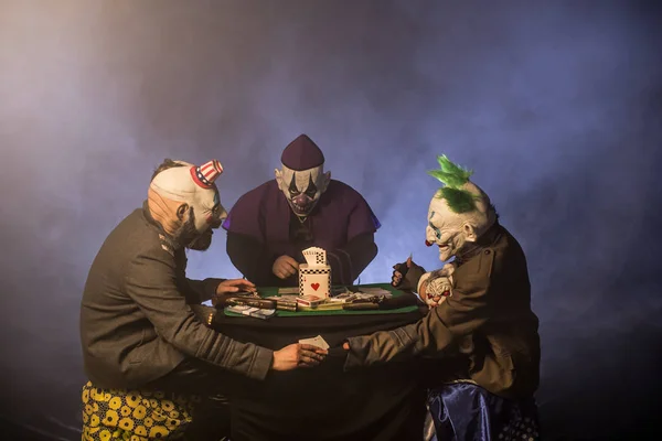 Läskiga Clowner Sitter Vid Bord Och Spela Poker Pengar Casino — Stockfoto