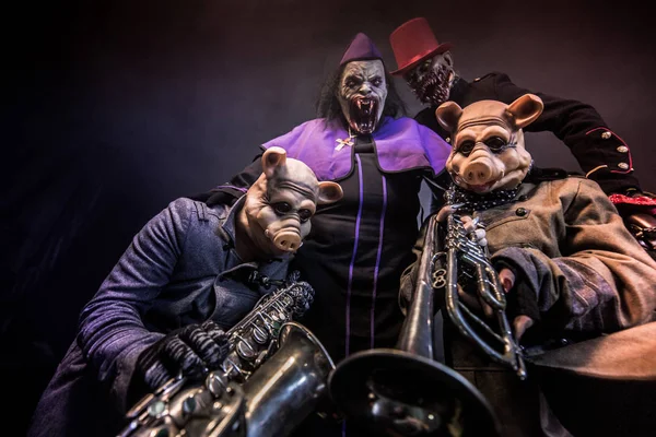 豚と楽器で暗い背景に一緒にポーズのピエロ — ストック写真