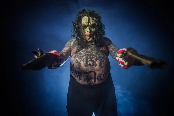 Tatuerade Scary Clown Poserar Med Kanoner Mot Dimmiga Bakgrund — Stockfoto