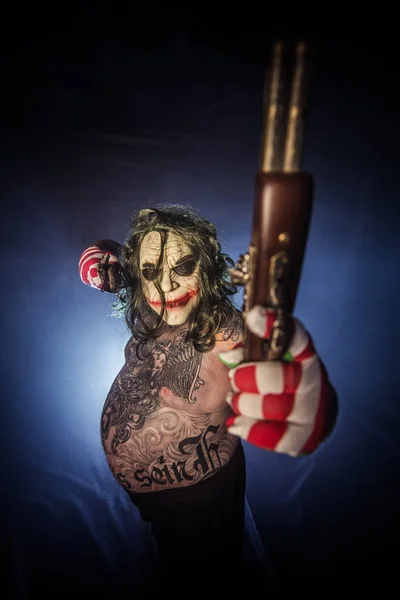 Tatuado Assustador Palhaço Posando Com Armas Contra Misty Fundo — Fotografia de Stock