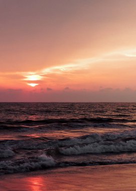 Sahilde turuncu bir gün batımı.