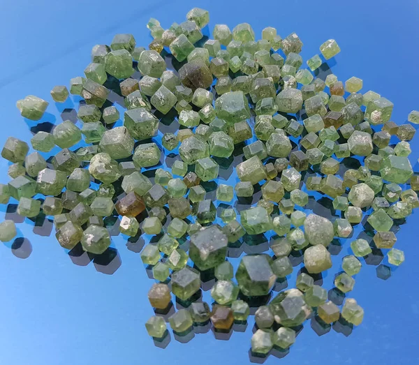 Demantoid Garnet mavi arka plan üzerinde izole